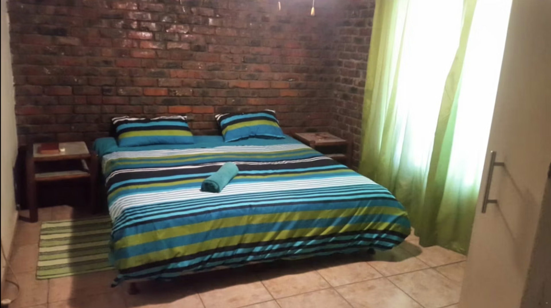 Bedroom with face-brick wall in Unit 1 at Do-Drop-In